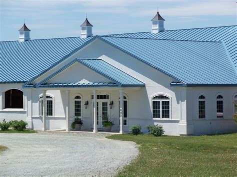 tan house with blue metal roof|house with blue roof.